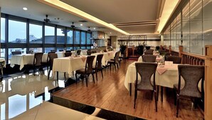 A spacious restaurant with multiple tables and chairs, large windows, and a modern interior design. - Hangzhou Wenhua Jinglan Grand Hotel (Hangzhou)