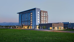 A modern hotel with a prominent 'Hyatt Place' sign, featuring a mix of glass and brick facades, and a parking lot in the foreground. - Hyatt Place Peña Station/Denver Airport (Denver)
