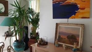 Een kamer met een houten kast, een lijst met een schilderij en een bloempot.