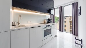 A modern kitchen with a built-in oven, a sink, and a coffee maker. - Apartamenty Sun & Snow Dune B (Mielno)