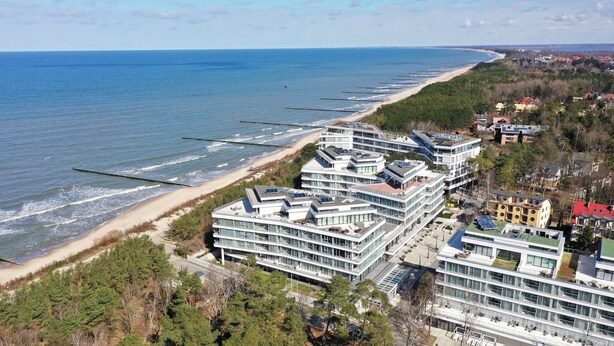 A coastal hotel with multiple modern buildings, a beach, and a view of the sea. - Apartamenty Sun & Snow Dune B (Mielno)