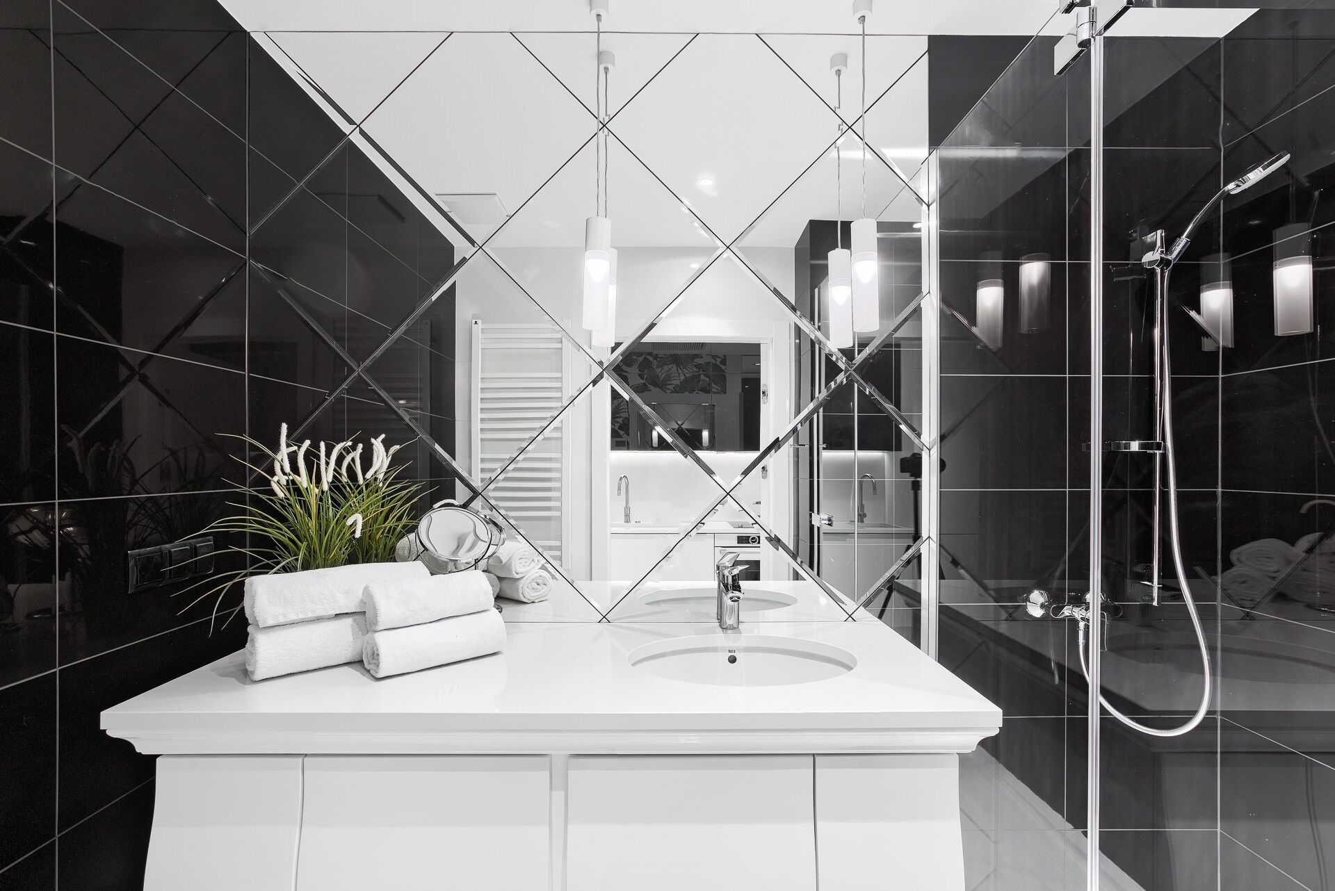 Un baño moderno con un espejo grande, un lavamanos y una ducha.