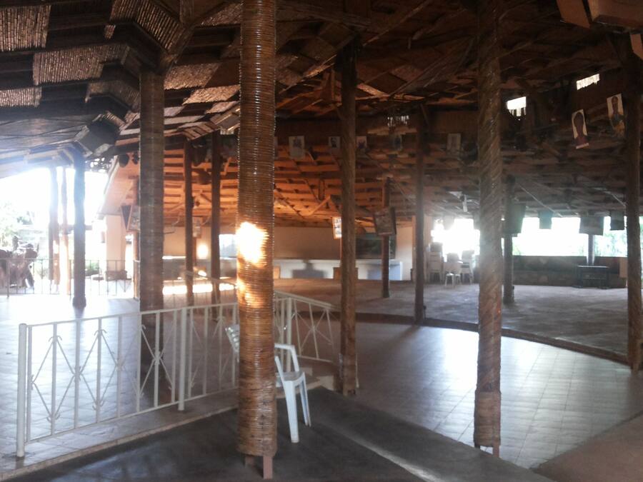 An interior with a high ceiling, exposed wooden beams, and a central column.