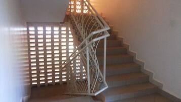 Un escalier avec une rampe en métal et un mur orné de motifs.
