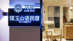 A hotel reception area with a sign displaying the hotel's name in both English and Chinese. - Floral Hotel Hangzhou Puyushanyu (Hangzhou)