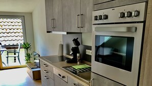 Eine moderne Küche mit grauen Schränken, einem Einbauofen und einer Kaffeemaschine.