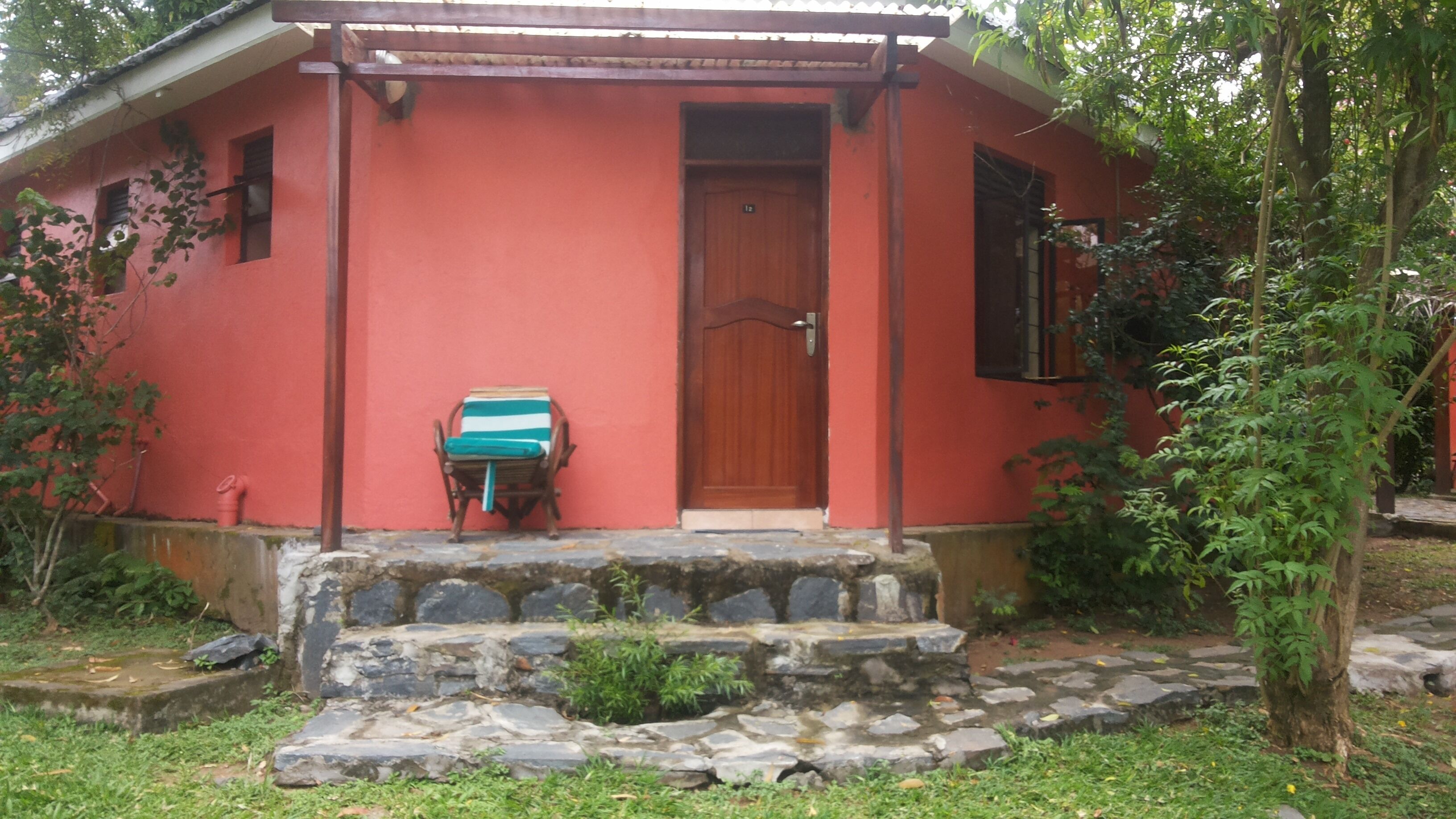A red building with a wooden door and a small porch.