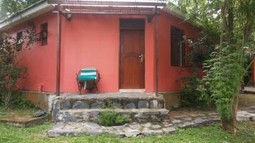 A red building with a wooden door and a small porch.