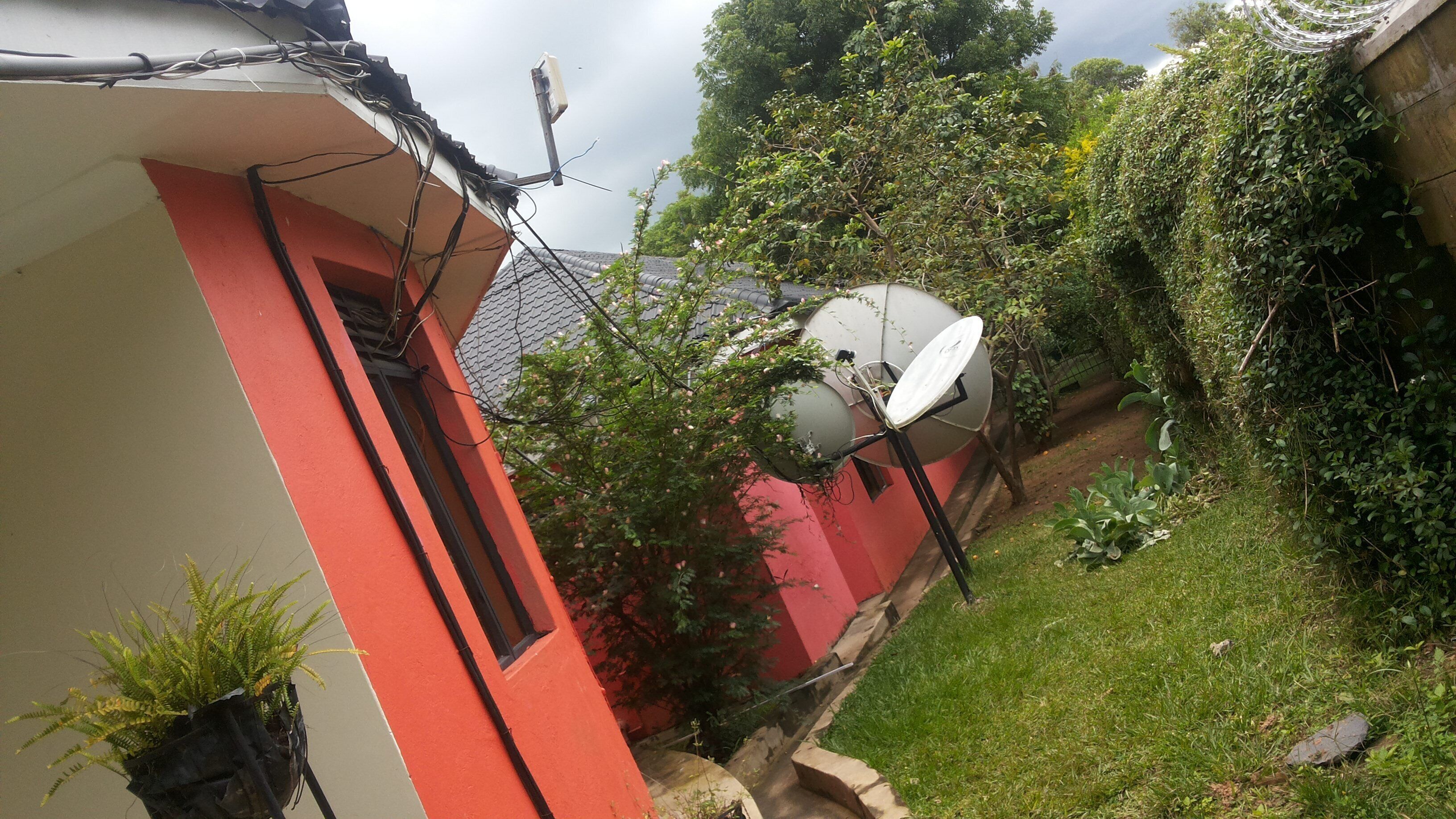 Um edifício vermelho e branco com antenas parabólicas e uma antena no telhado.