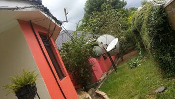 Um edifício vermelho e branco com antenas parabólicas e uma antena no telhado.