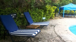 Alberca al aire libre y camastros 