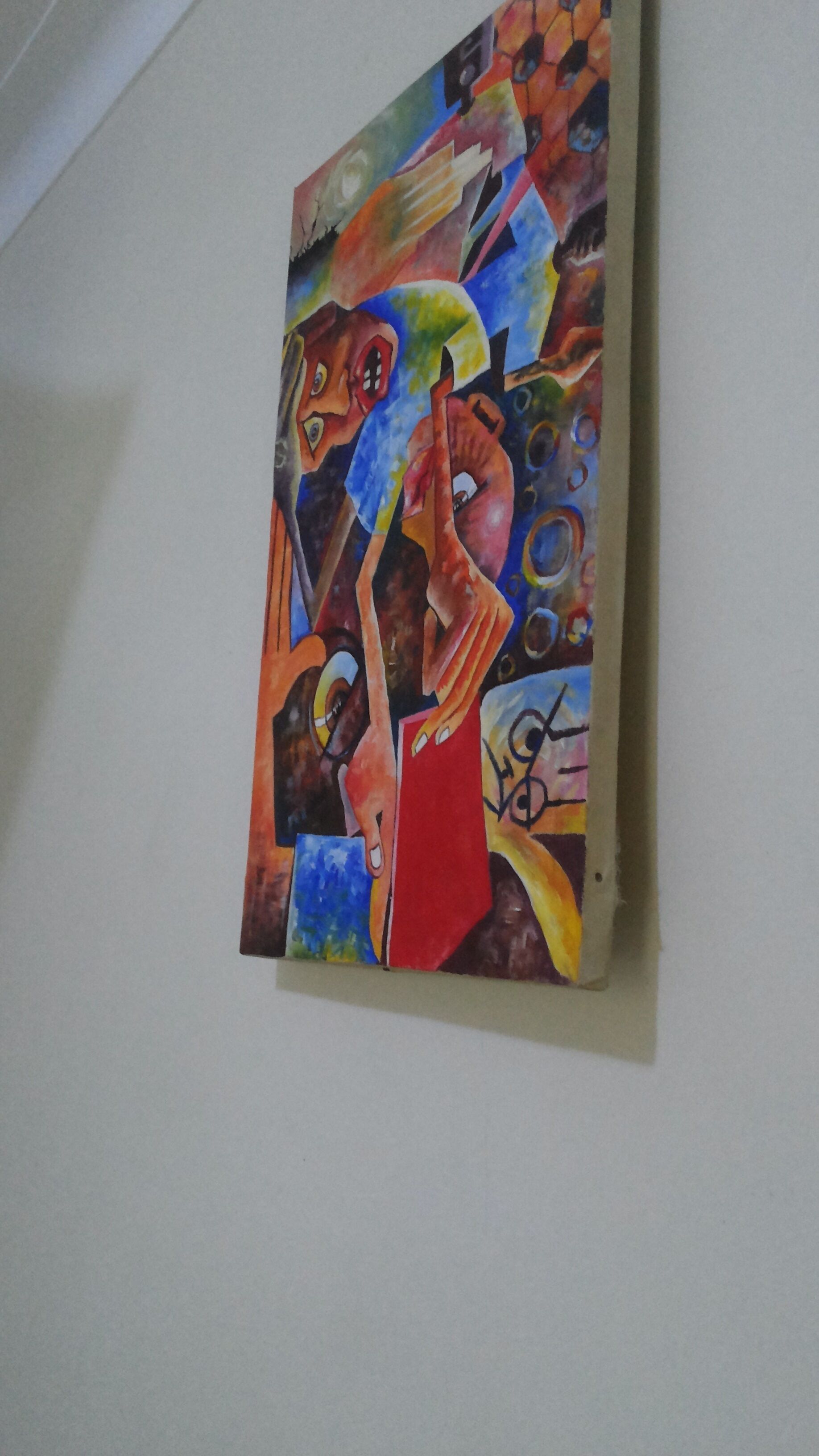 A painting with abstract figures and vibrant colors on a wall.