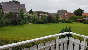A residential area with houses, a well-maintained lawn, and a white picket fence. - Upper apartment in Westeraccum with balcony (Westeraccum)