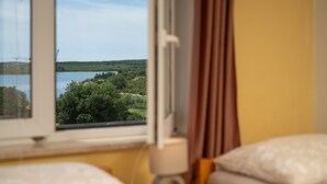 Een kamer met uitzicht op water en groen.