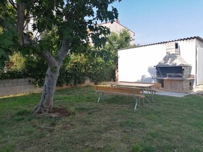 A backyard with a barbecue grill, picnic table, and a tree. - Apartments Tara Apt 2 (Medulin)