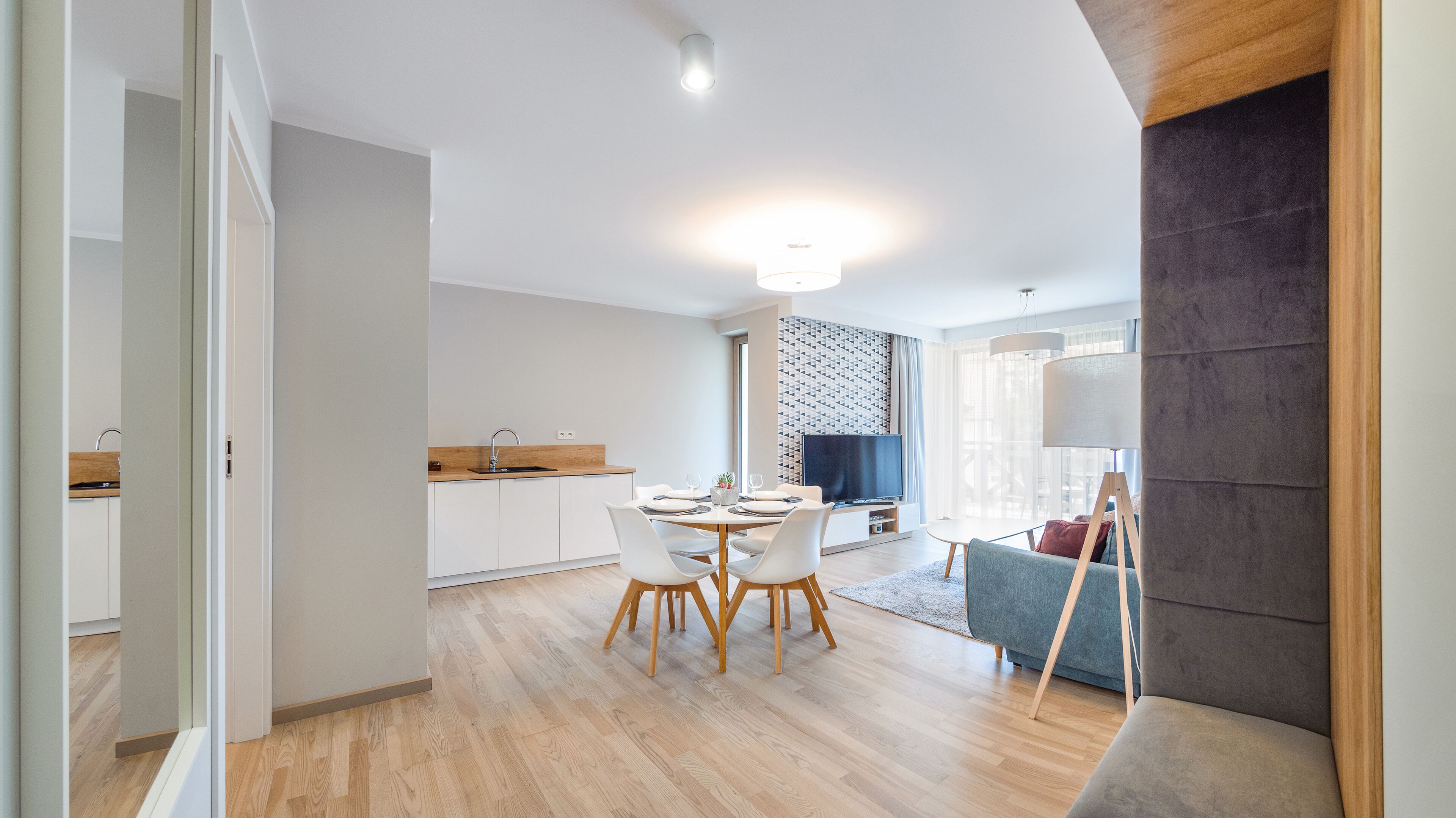 A modern kitchen with white cabinets, a wooden countertop, and a built-in oven.