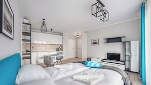 A modern hotel room with a large bed, a desk, and a TV. - Apartamenty Sun&Snow Rezydencja Park (Mielno)