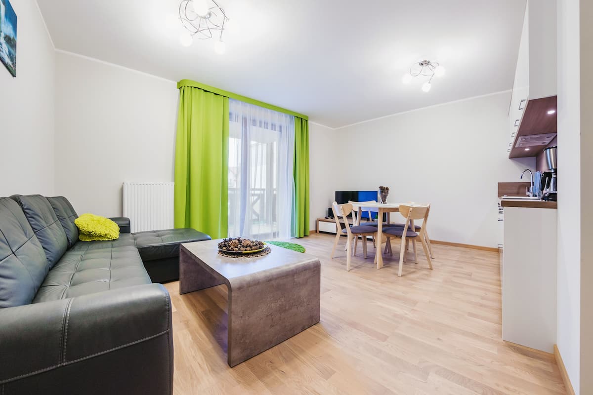 Una sala de estar moderna con un sofá, una mesa de centro y un comedor con mesa y sillas.