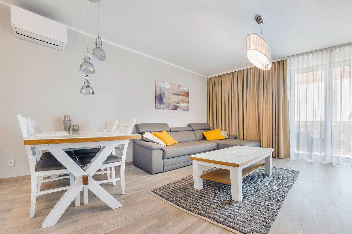 Una sala moderna con sofá, mesa de centro y comedor.
