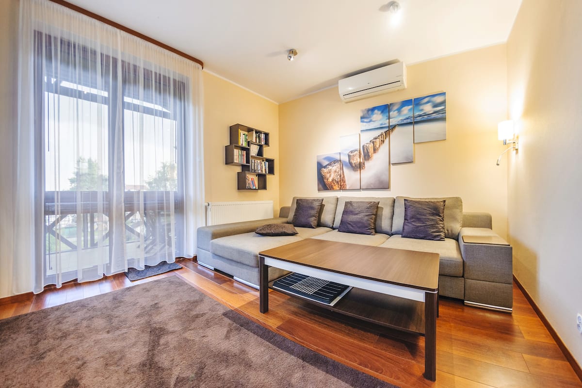 Una sala de estar moderna con un sofá, una mesa de centro y una estantería.