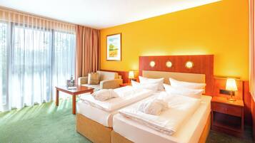A hotel room with a double bed, two bedside tables, a chair, a desk, a lamp, and a painting on the wall.