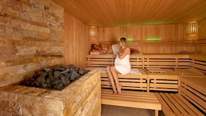 En sauna med træbænke og en stenspis.