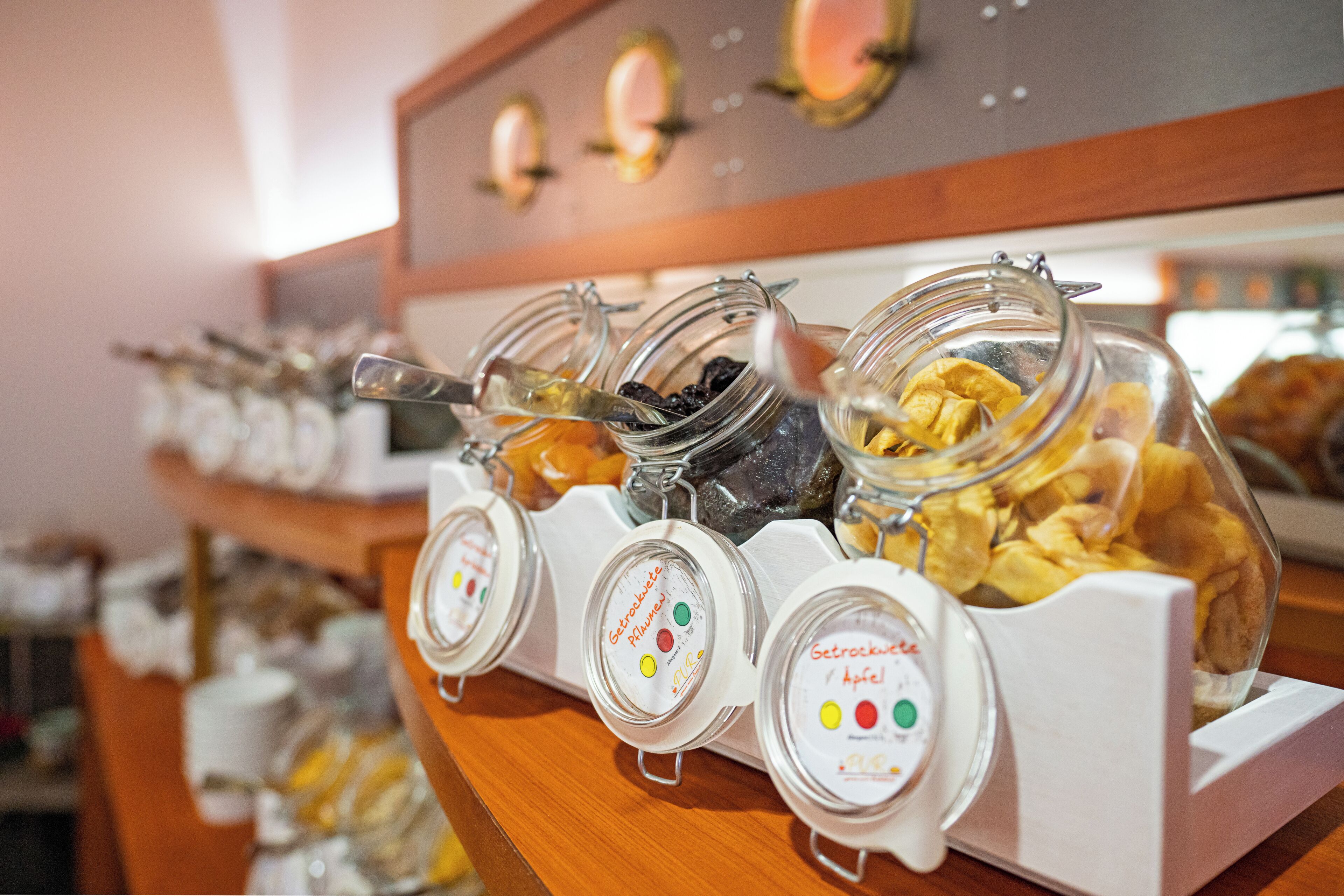 Un bufé de desayuno con diversos alimentos en recipientes de vidrio.