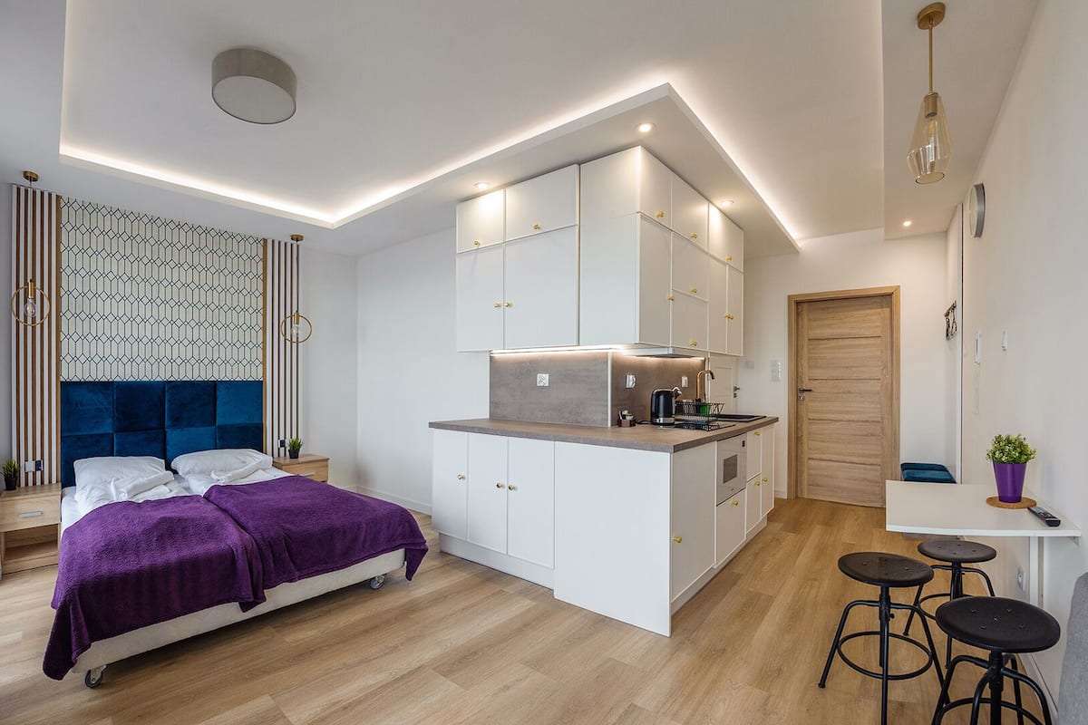 Ein kleines Hotelzimmer mit Bett, einer Küchenzeile, einer Essecke und einem Badezimmer.