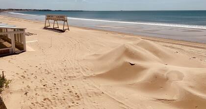 Ranta ja aurinko, rakennus rannan takana