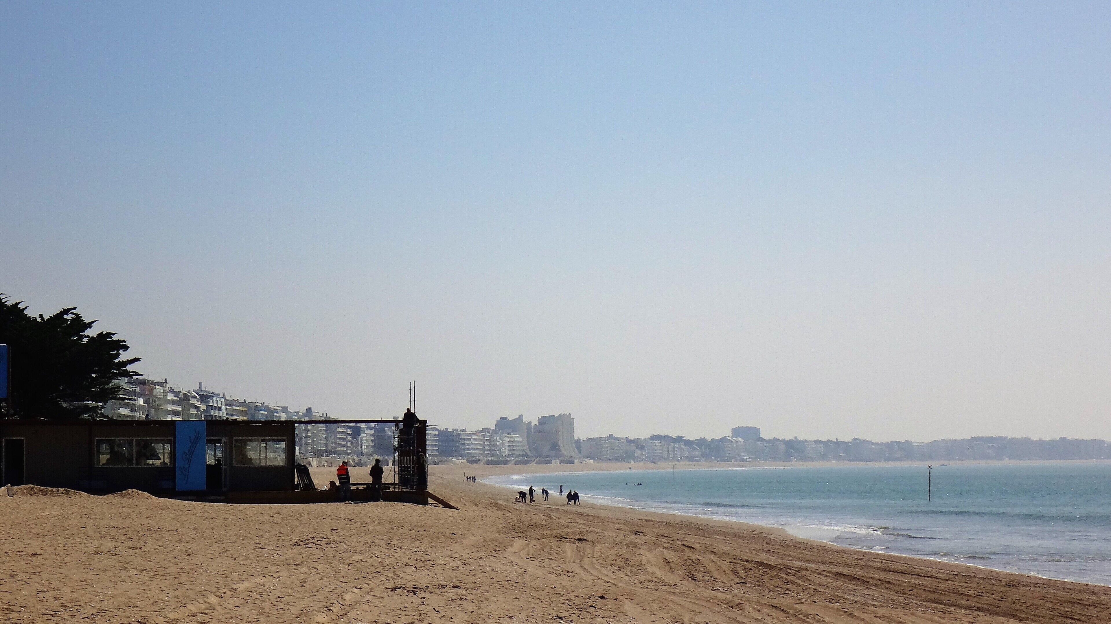 A beach with a lifeguard tower and a clear view of the ocean.