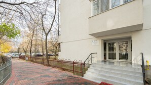 A building entrance with a red brick pathway leading to a set of stairs. - Studio 37 by MRG Apartments (Bucharest)