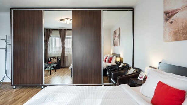 A hotel room with a large bed, a mirror, a desk, and a chair. - Studio 37 by MRG Apartments (Bucharest)