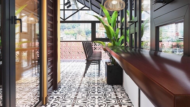 A modern interior with a patterned floor, a wooden counter, and a chair. - Tabalo Hostel Hanoi (Hanoi)