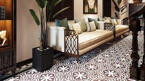 A modern living room with a sofa, decorative plants, and a patterned floor. - Tabalo Hostel Hanoi (Hanoi)