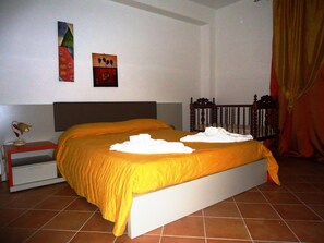 A bedroom with a bed, a nightstand, a lamp, and two wall art pieces.