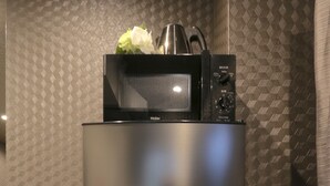 A modern kitchen with a stainless steel refrigerator and a microwave on top. - Elizabeth Garden Shinmachi (Osaka)