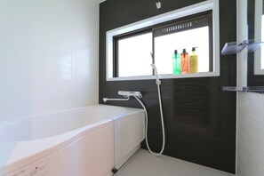 A modern bathroom with a bathtub, a window, and a shower. - Elizabeth Garden Shinmachi (Osaka)