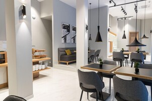 Moderni sisustus, jossa on ruokailutila, sohva ja taustalla keittiö.