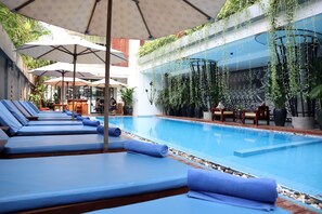 Una piscina al aire libre, sombrillas