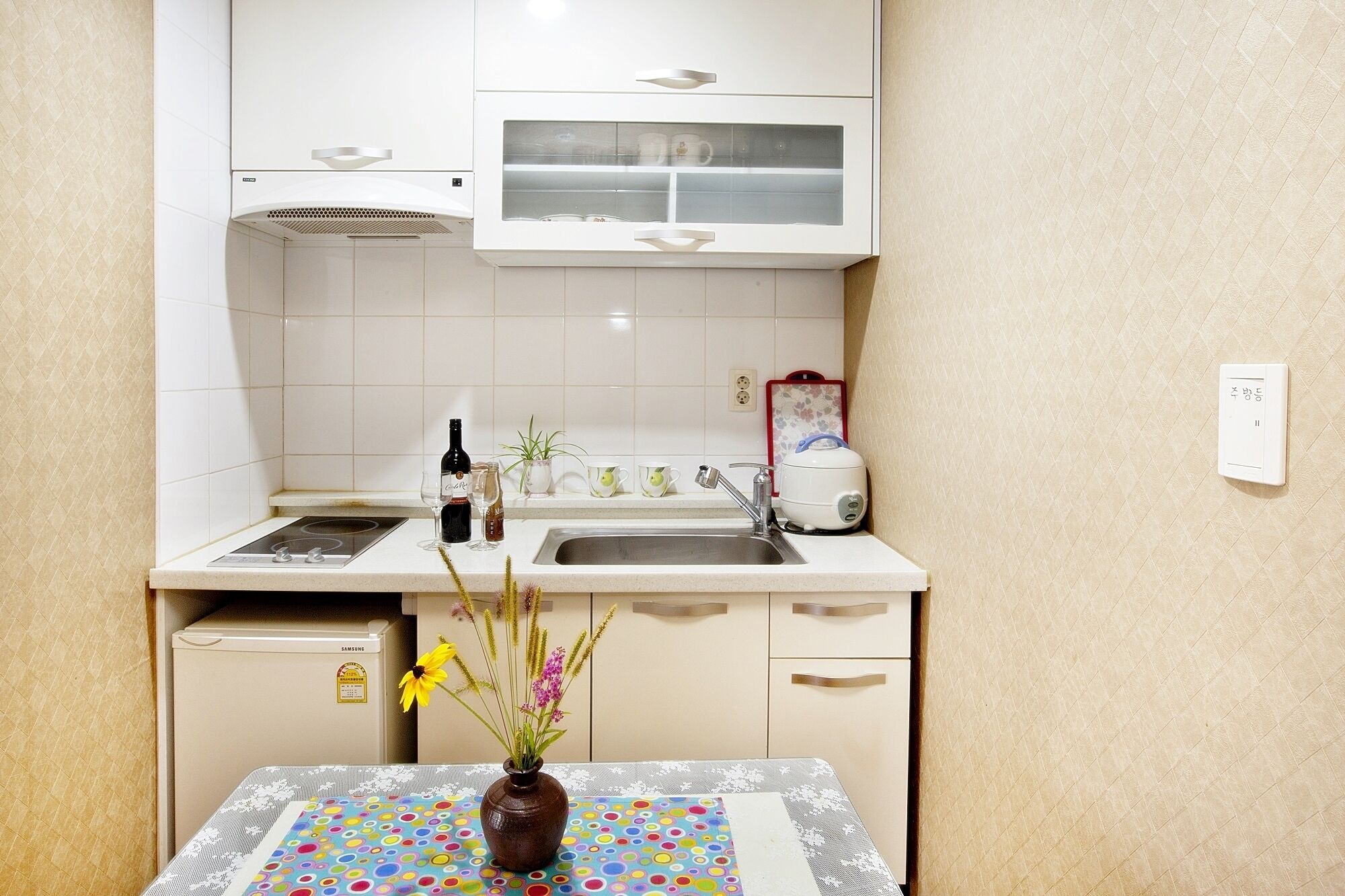 A small kitchenette with a microwave, a sink, and a cabinet above.