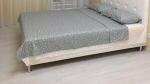 Makuuhuone, jossa on sänky, verhot ja ilmastointilaite.