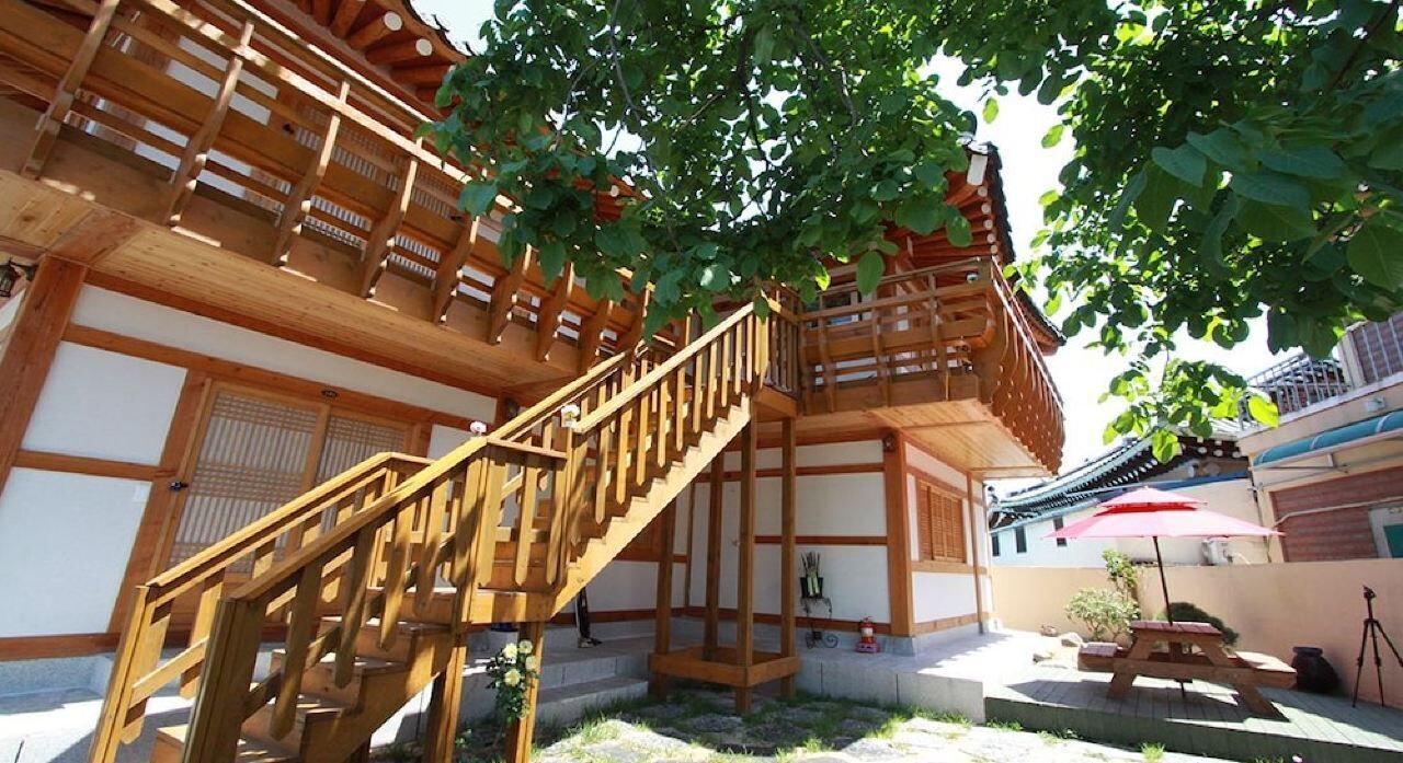 A traditional Japanese wooden building with a wooden staircase leading to an upper level.
