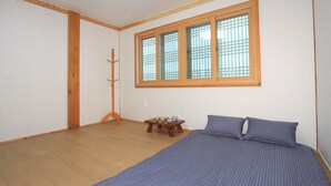 Une chambre à coucher avec un lit, une fenêtre et une petite table sur laquelle se trouvent divers objets.