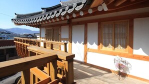 Un bâtiment traditionnel japonais doté d’un balcon en bois, de murs blancs et d’un toit recouvert de tuiles.