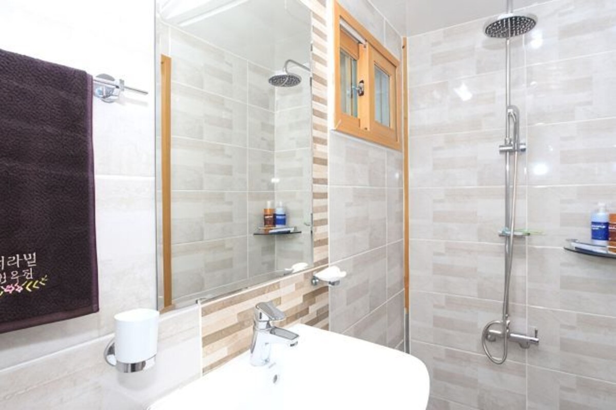 A modern bathroom with a shower, a sink, and a mirror.