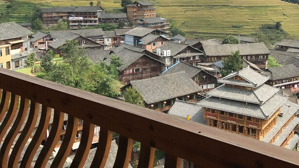 A traditional village with tiered rice paddies and wooden buildings. - Pingan Hotel (Guilin)