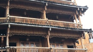 A traditional multi-story wooden building with balconies and a stone base. - Pingan Hotel (Guilin)