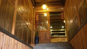 A wooden staircase leading to a room with a traditional design, including lattice panels and a hanging light fixture. - Pingan Hotel (Guilin)