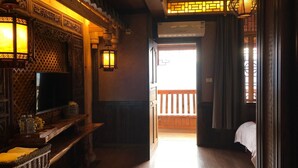 A traditional interior with a wooden bench, a television, and a wall-mounted air conditioner. - Pingan Hotel (Guilin)