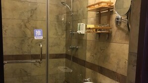 A bathroom with a glass-enclosed shower, a white toilet, and a black bidet. - Pingan Hotel (Guilin)